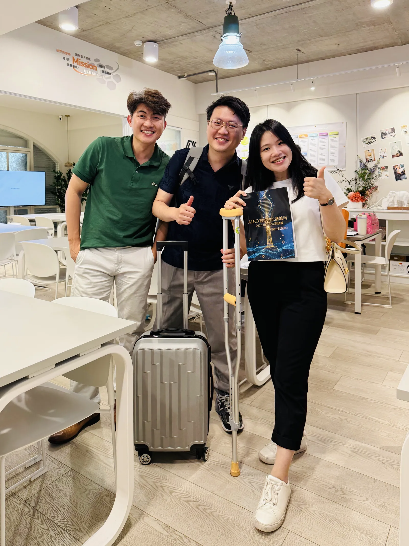 心臟科連思涵醫師腳傷未癒仍拄著拐杖到場參加 AI 時代的數位護城河小班制課程，課後與張益豪醫師等人在教室合影，手中是當天的 AIEO 醫療數位護城河完整講義