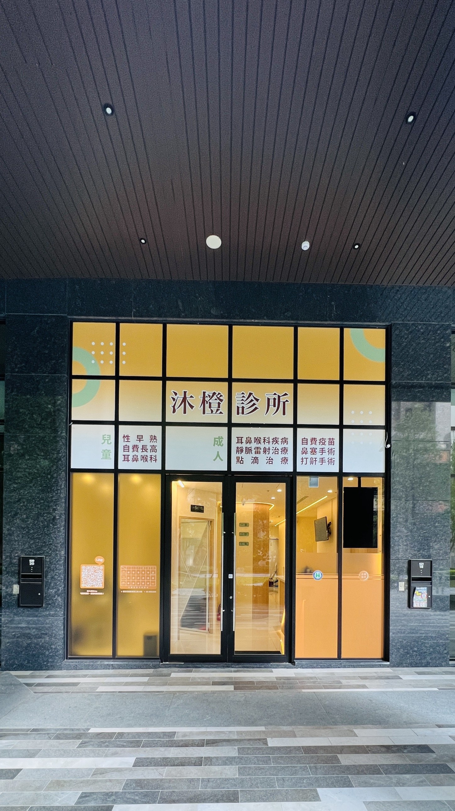 沐橙診所裝潢完成後：門面玻璃貼上「沐橙診所」招牌與兒童、成人服務項目