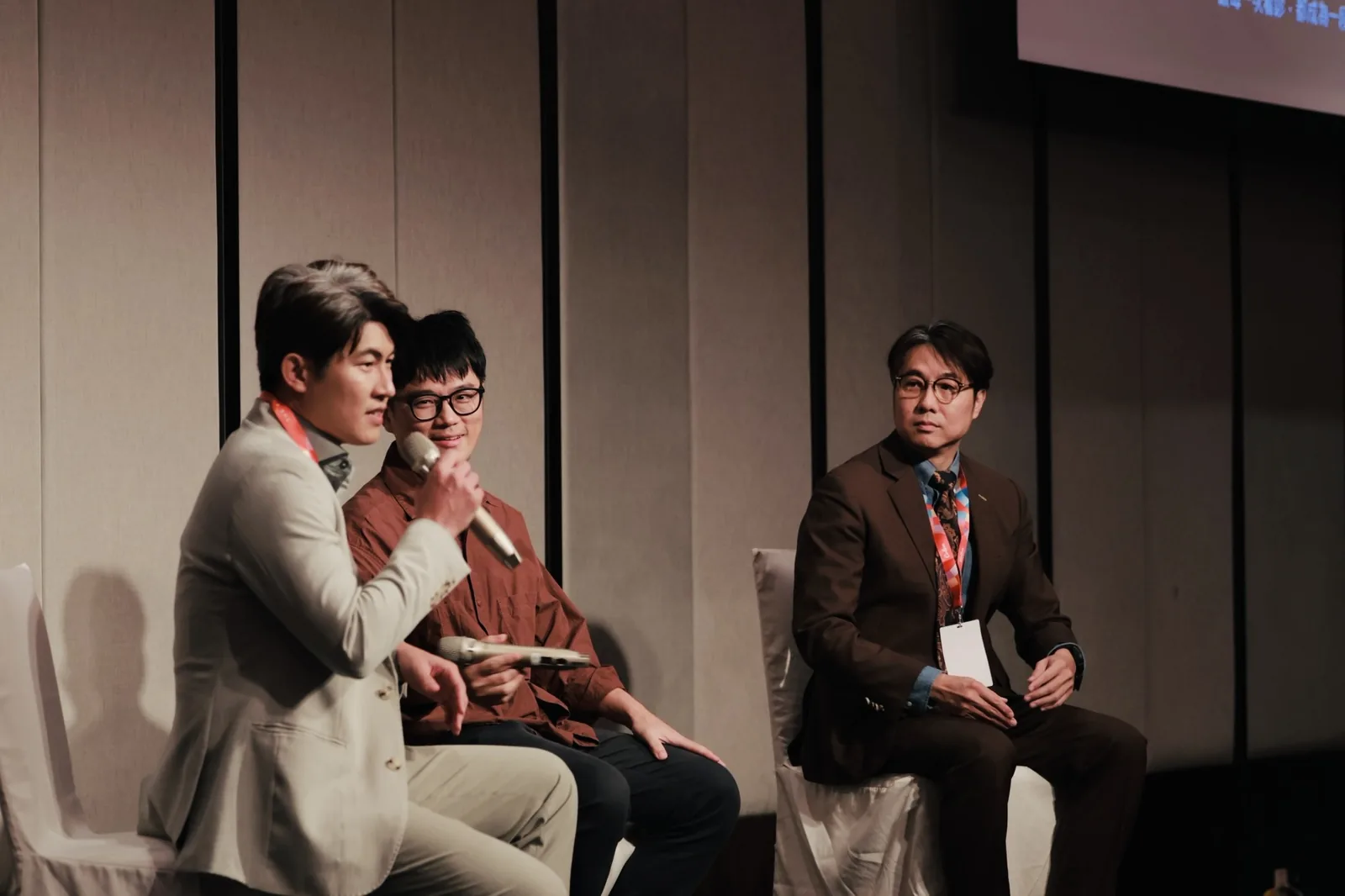 來日方腸 2026 研討會 B 廳 Panel discussion 時段，張益豪醫師手持麥克風，與講者黃煜晏醫師、中華民國大腸直腸外科醫學會秘書長邵彥誠醫師同台