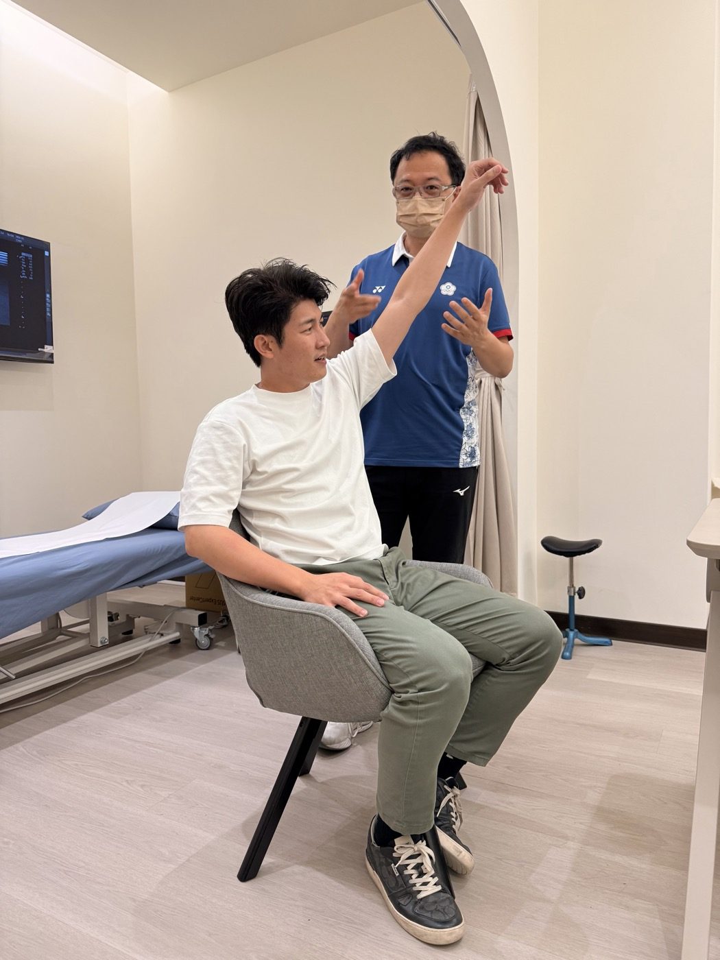 關節活動度評估：張益豪醫師主動將左手臂高舉過頭，由林頌凱醫師評估