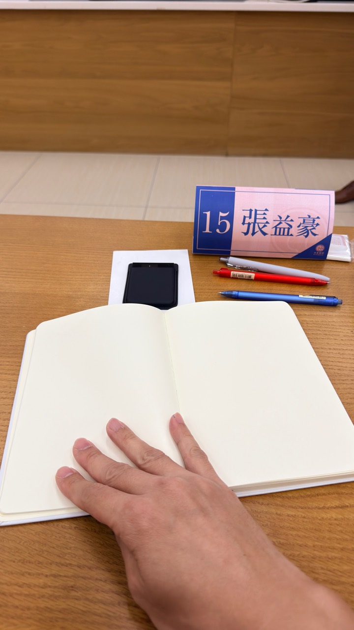 課桌上的空白筆記本、文具與張益豪名牌。