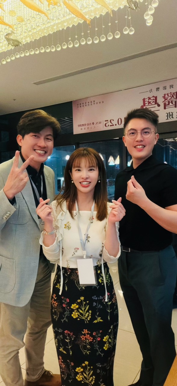 三位參與者在活動現場合影，背景可見課程海報。