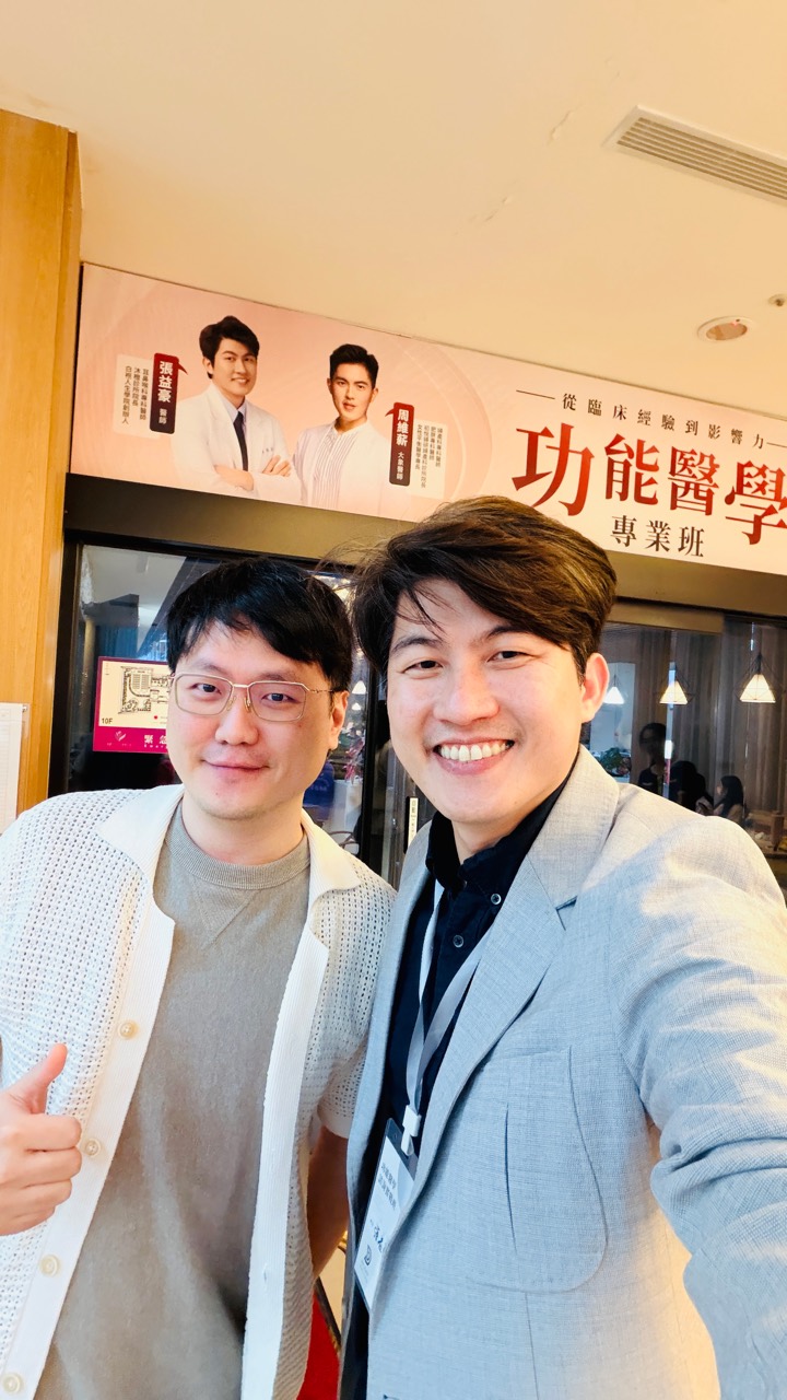 兩位參與者在功能醫學專業班活動布條前合影。