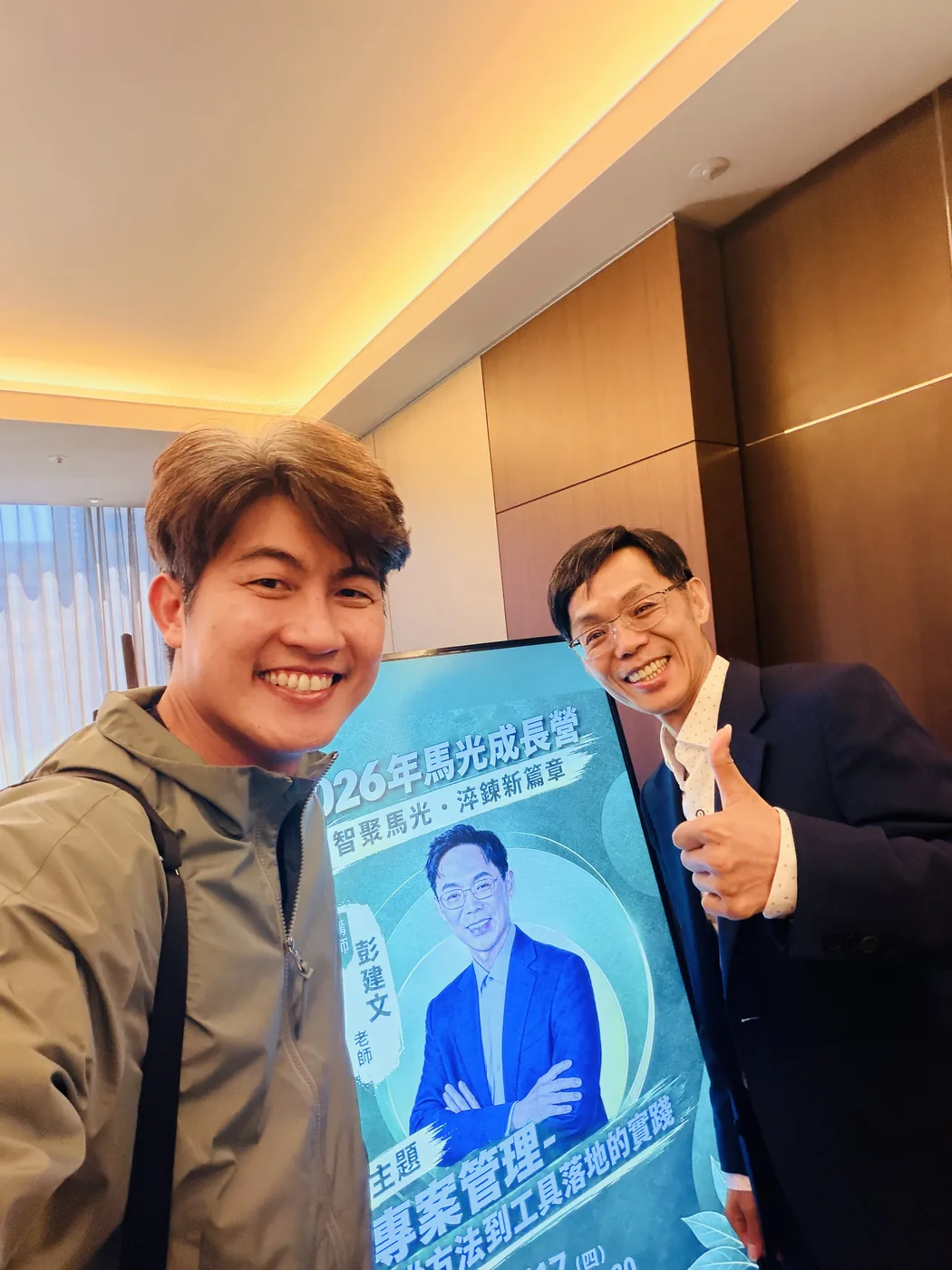 張益豪醫師與講者彭建文老師在課程海報前合照，海報主題為專案管理課程