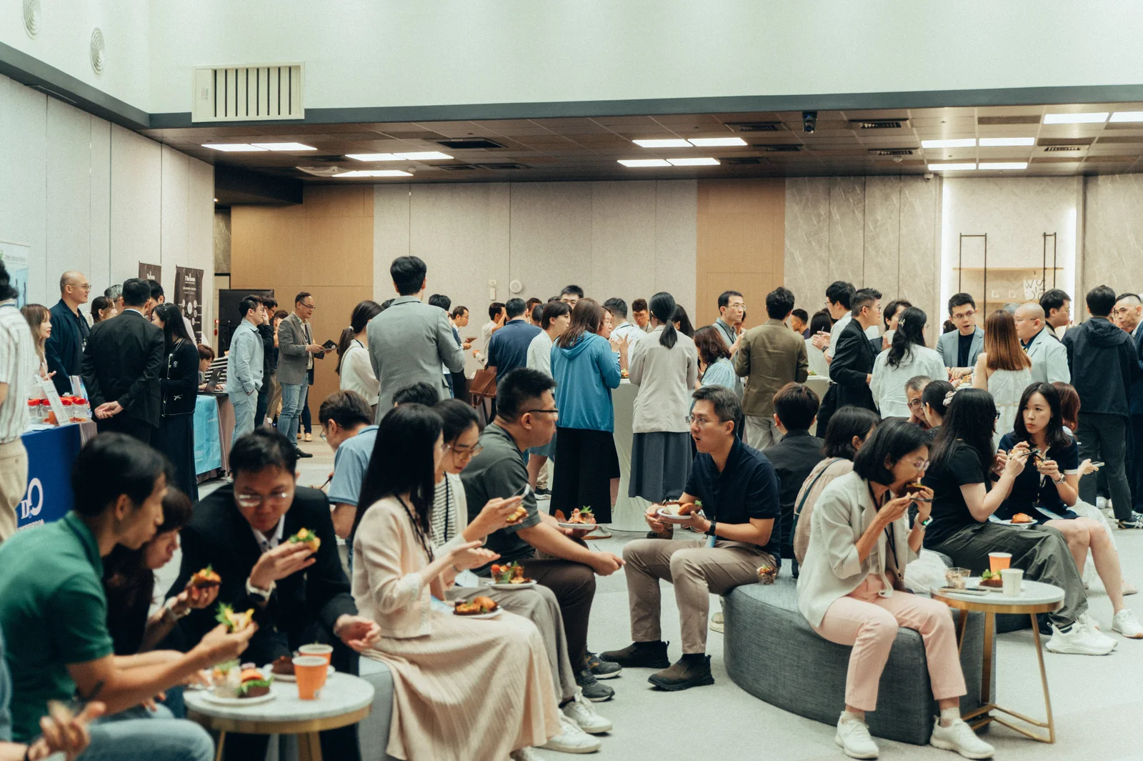 2026 高峰年會與會者在會場外用餐，分組坐著或站著交談