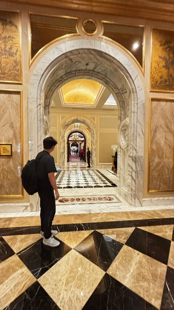 背著背包走在旅館走廊中的旅行情境