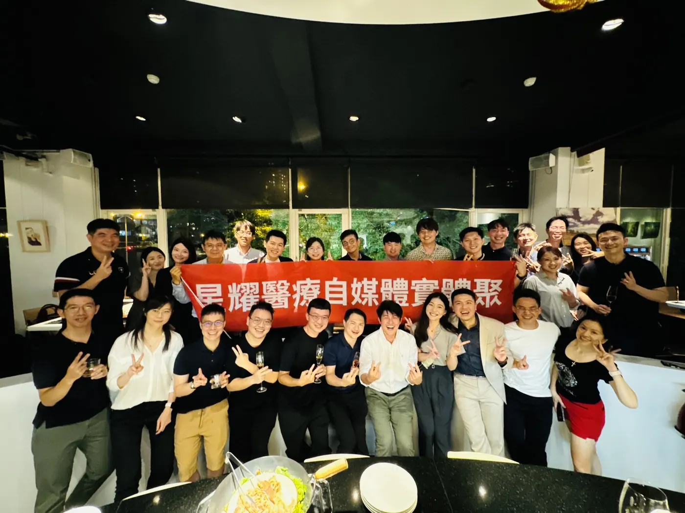 與會者在吧台前拉起「星耀醫療自媒體實體聚」紅布條大合照