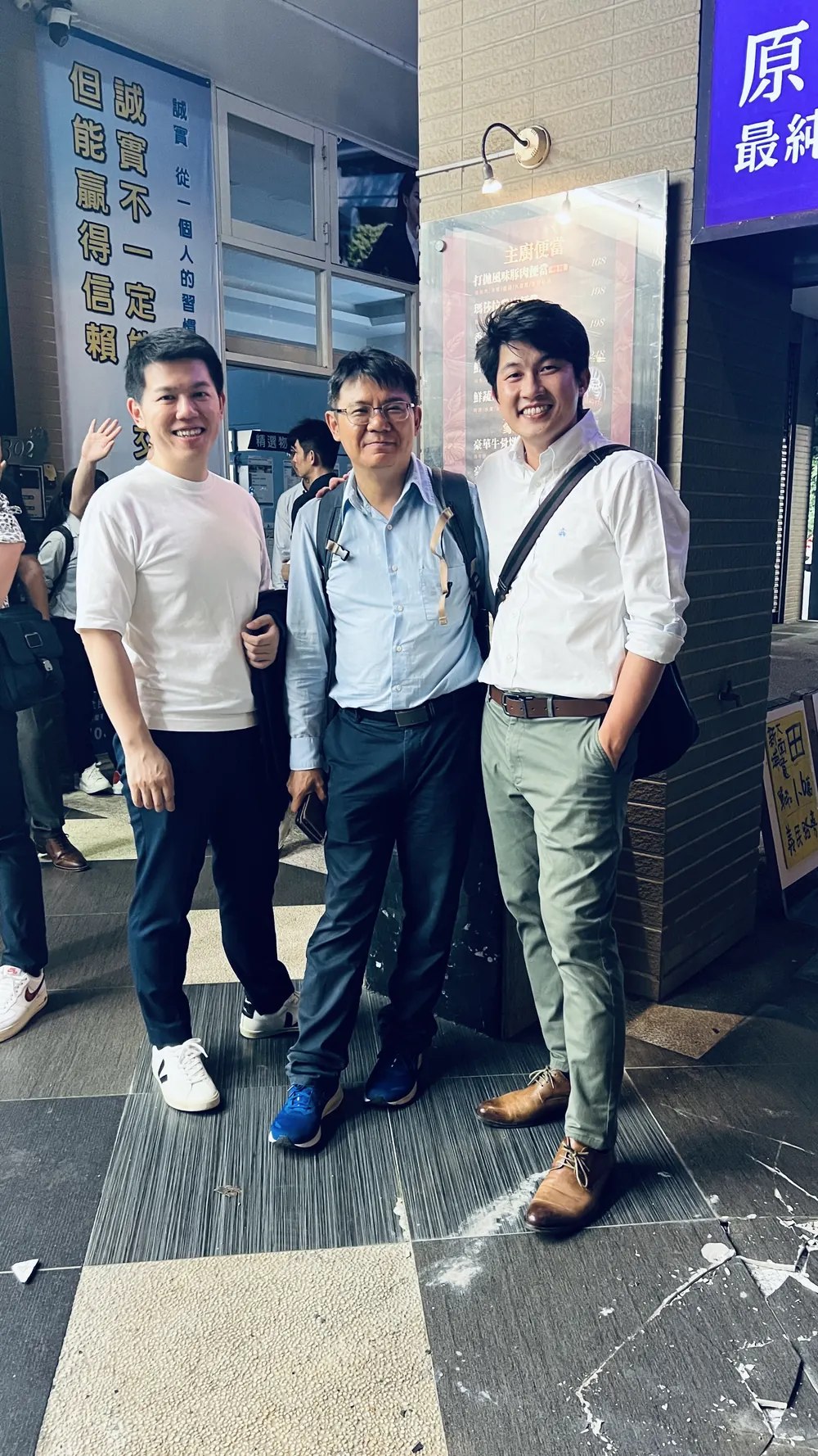 三位與會者在餐廳樓下的騎樓合影