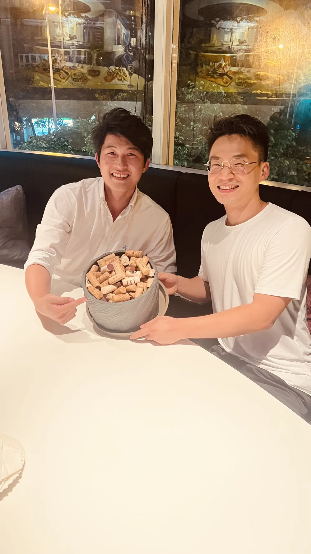 兩位與會者捧著一盆裝滿軟木塞的盆子合影