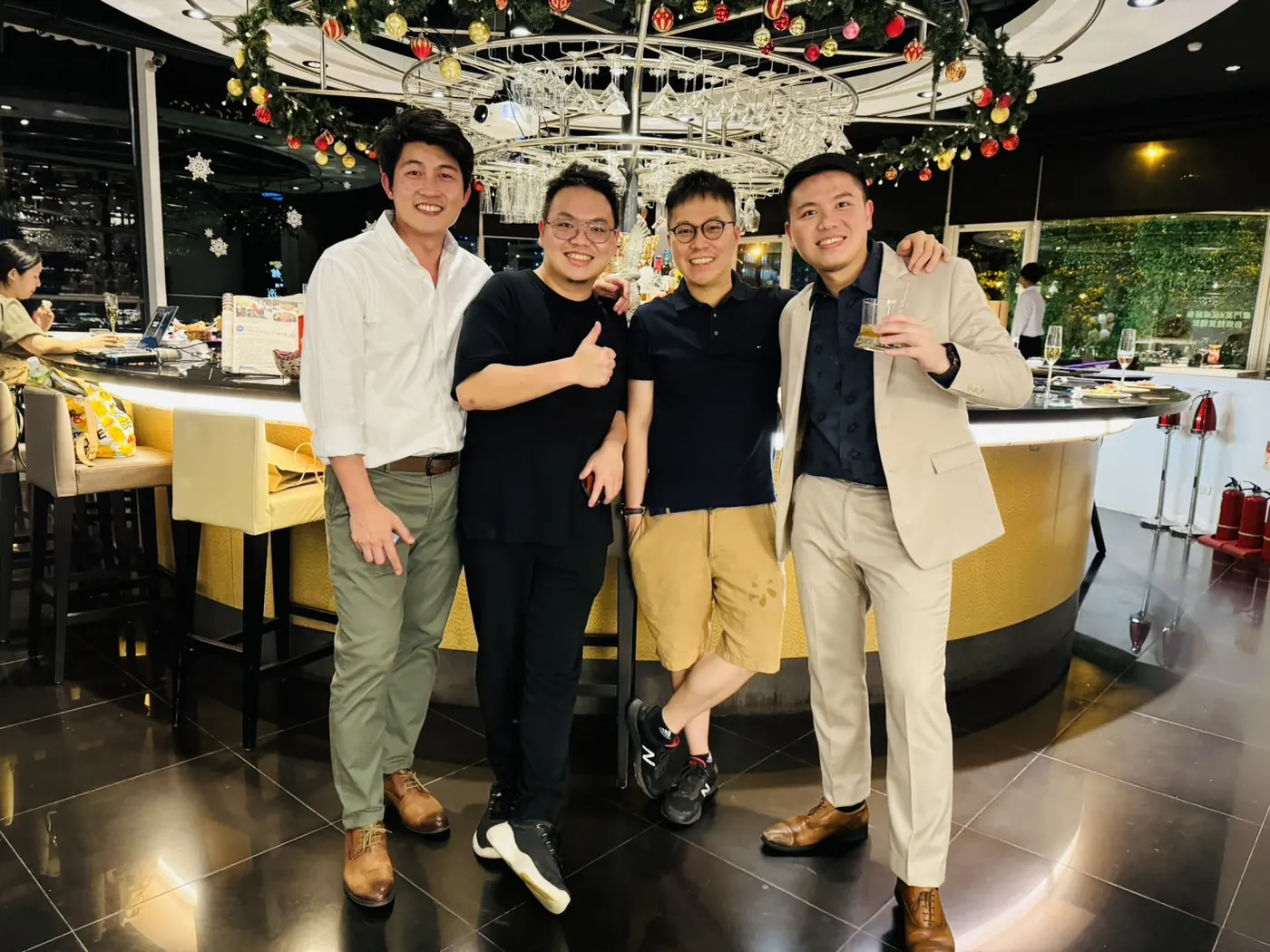 四位與會者在圓形吧台前合影