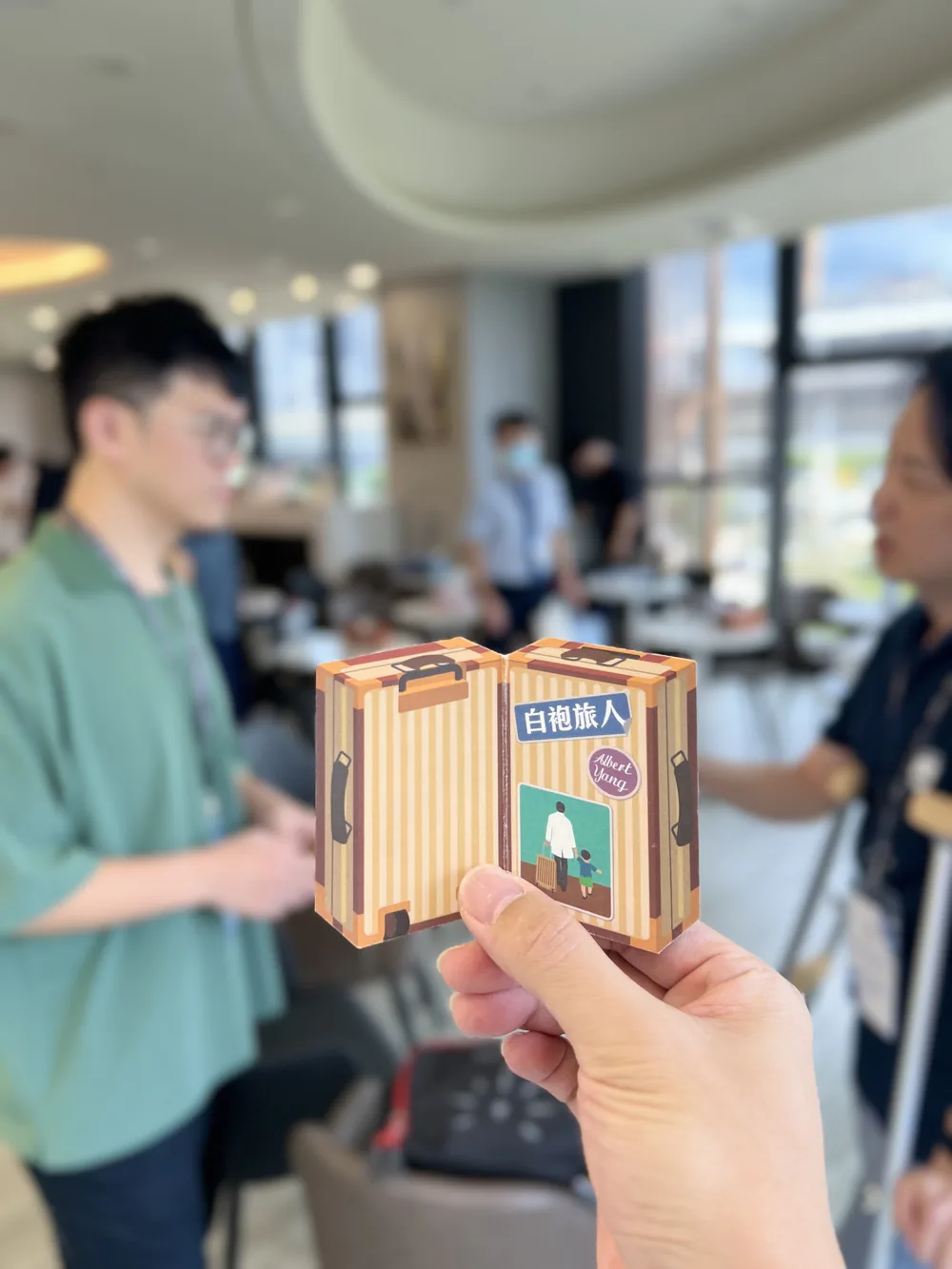 一位與會者手持白袍旅人的名片盒