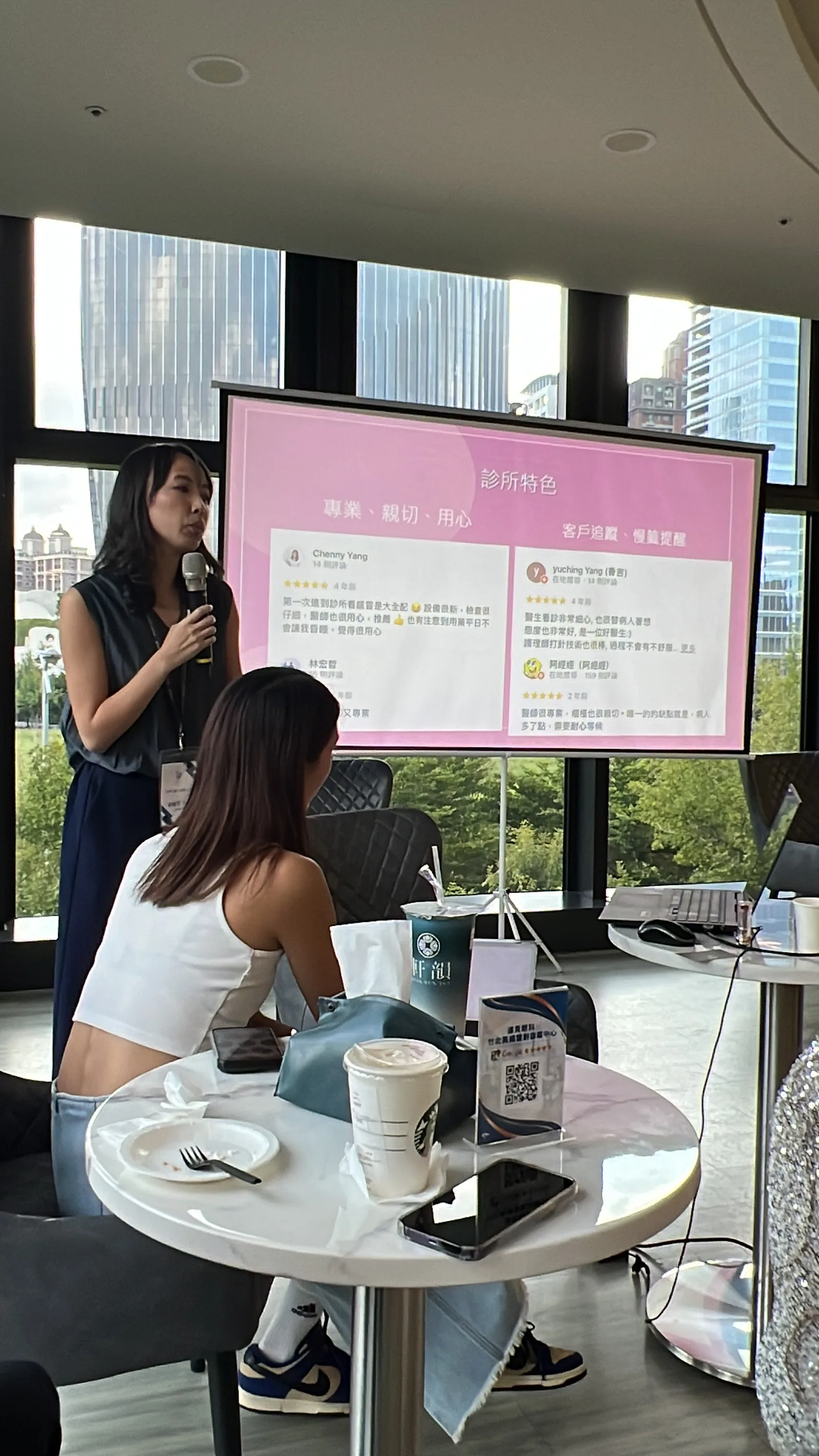 兩位講者並肩站在投影幕旁分享
