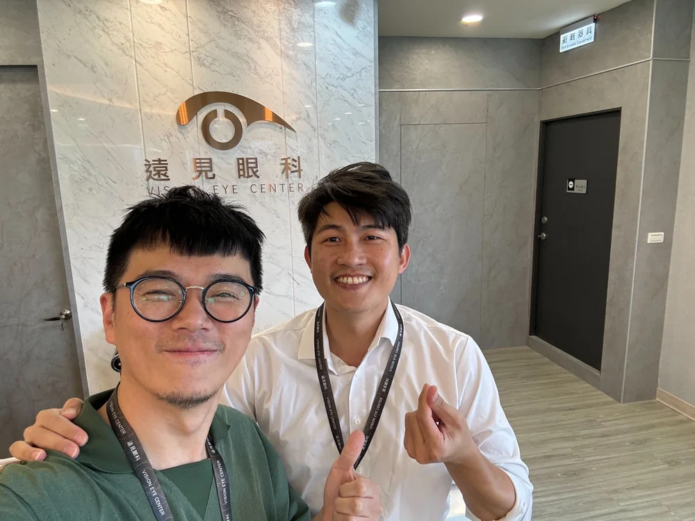 張益豪醫師與一位院長在遠見眼科招牌前自拍