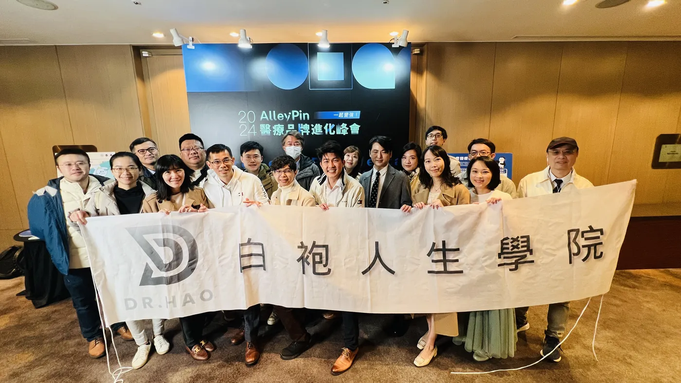 學院成員在會場入口排成兩排，一起拉開白色「白袍人生學院」布條合影，背後是「2024 AlleyPin 醫療品牌進化峰會」主視覺背板