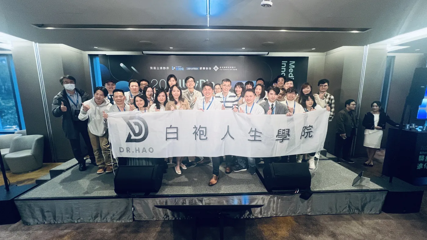 學院成員站上舞台，拉開「白袍人生學院」布條大合照，背後是峰會主視覺背板，舞台前緣有兩個音響