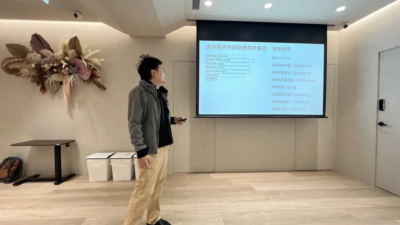 陳昱傑醫師站在債券資產內部報酬率計算表投影片旁分享