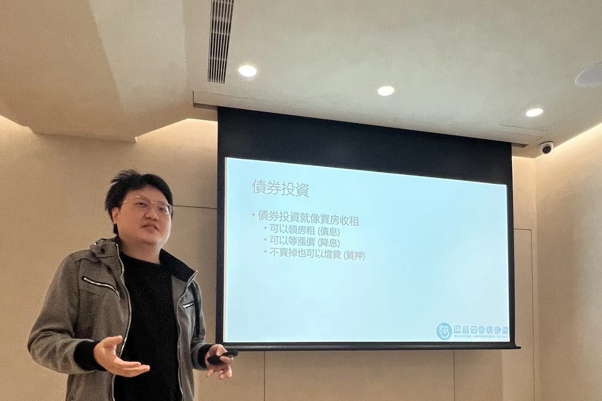 陳昱傑醫師站在「順勢投資」投影片旁分享債券質押