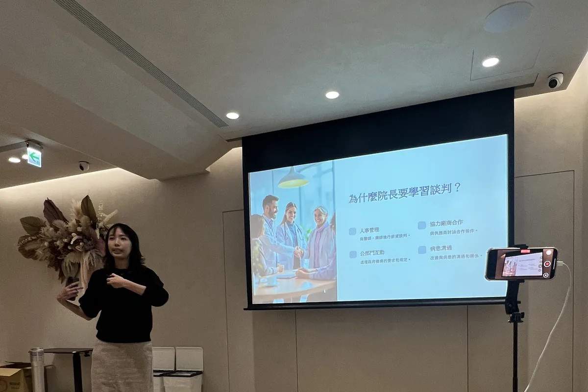 劉麗雪醫師站在「為什麼院長要學習談判？」投影片旁分享