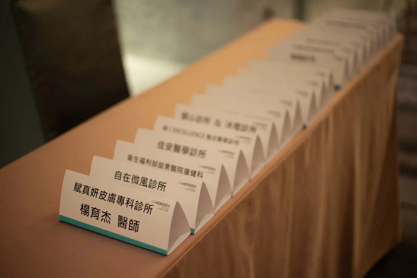 一排寫著講者姓名與診所的桌卡