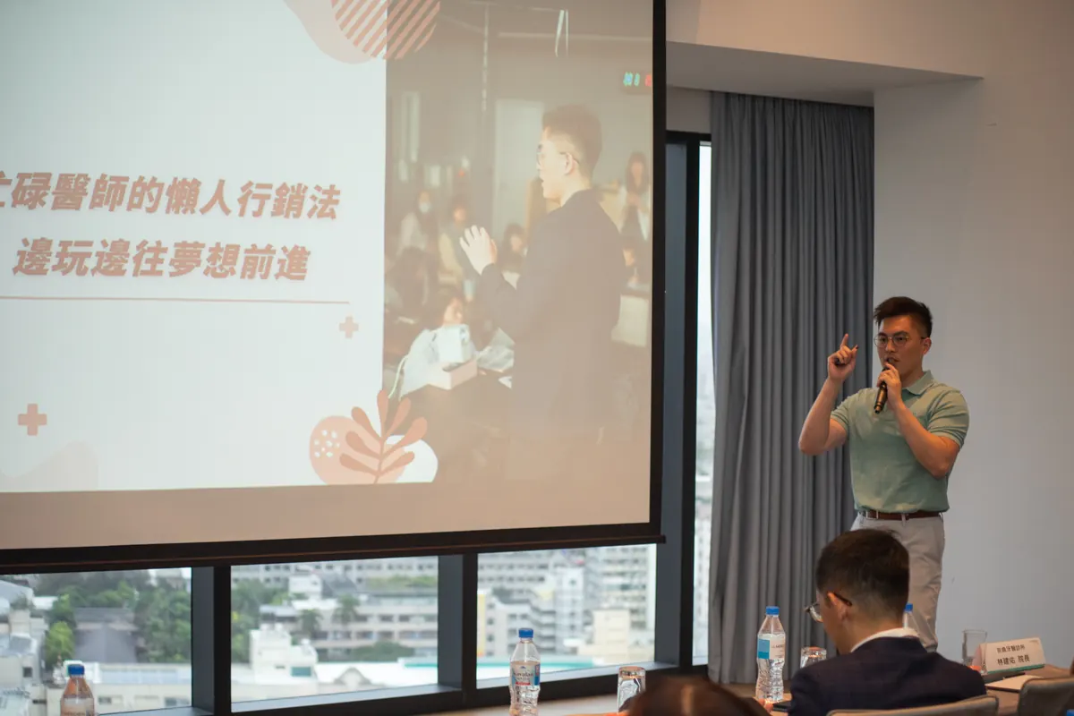 周維薪醫師站在「忙碌醫師的懶人行銷法」投影片旁分享