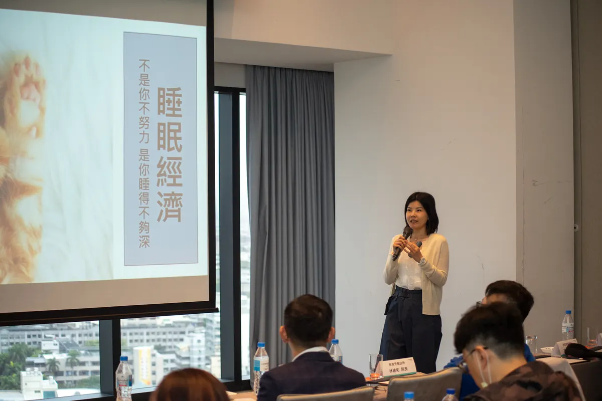 許瑛倢醫師站在「睡眠經濟」投影片旁分享