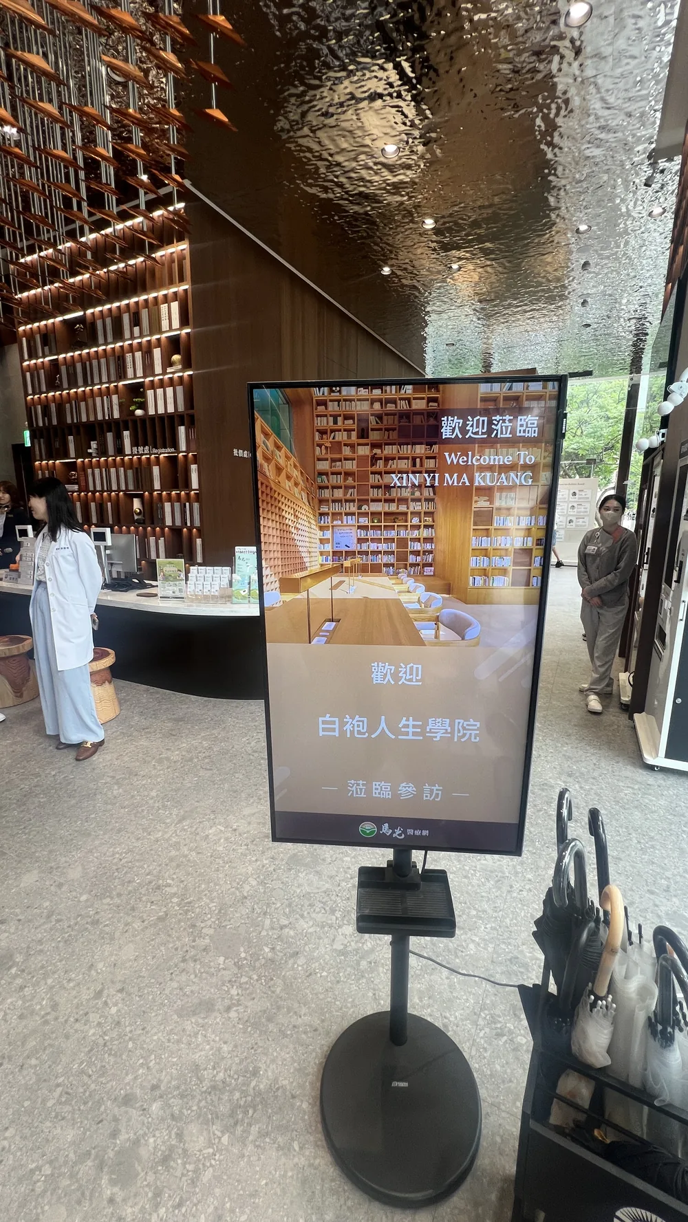馬光中醫信義旗艦店門口的電子立牌，寫著歡迎白袍人生學院
