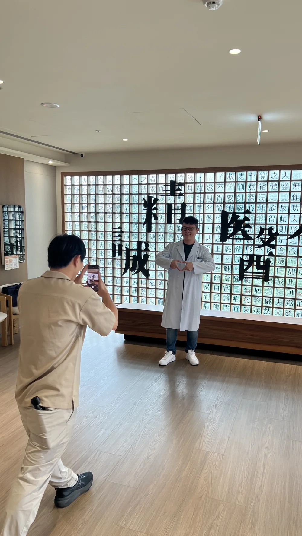 一位醫師站在「精誠」字牆前