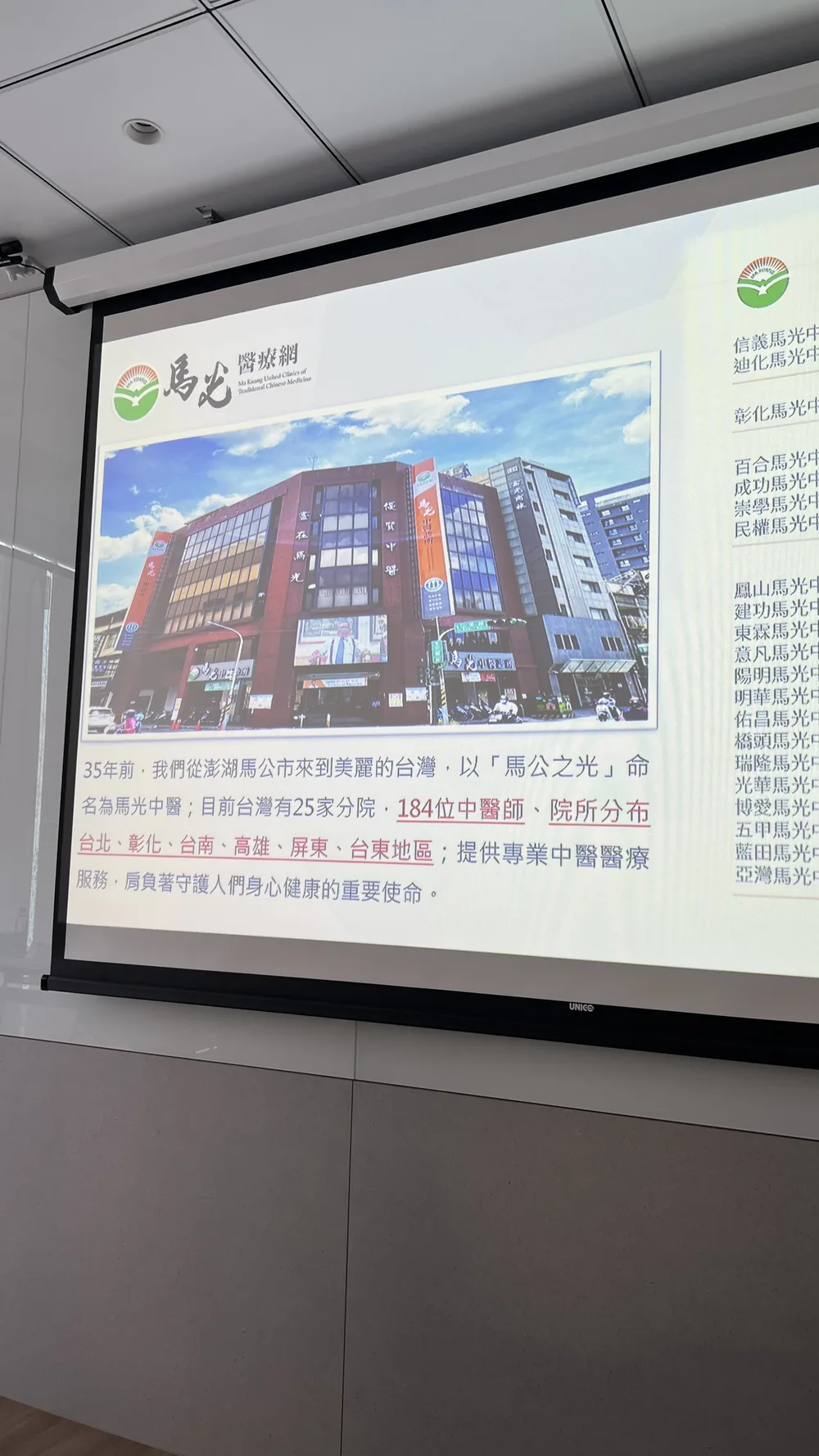 投影幕顯示馬光醫療網的介紹投影片