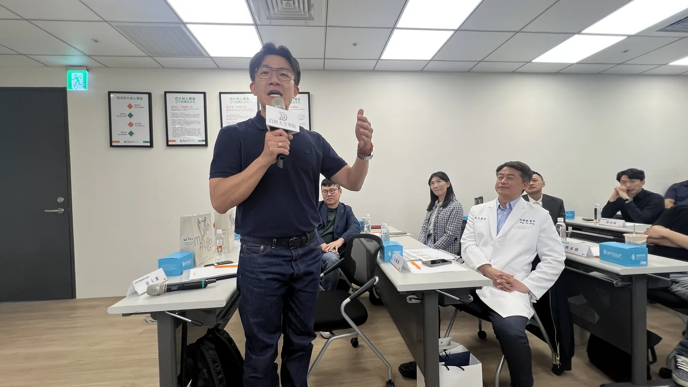 一位參訪醫師起身發言，旁邊的醫師舉手