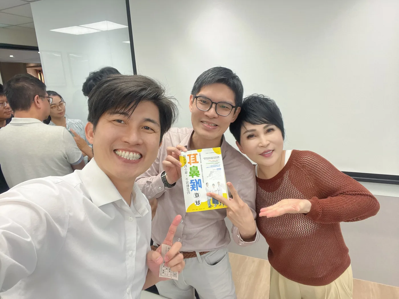 李俊廷醫師手持帶來的書，與王瑞玲、張益豪醫師合影