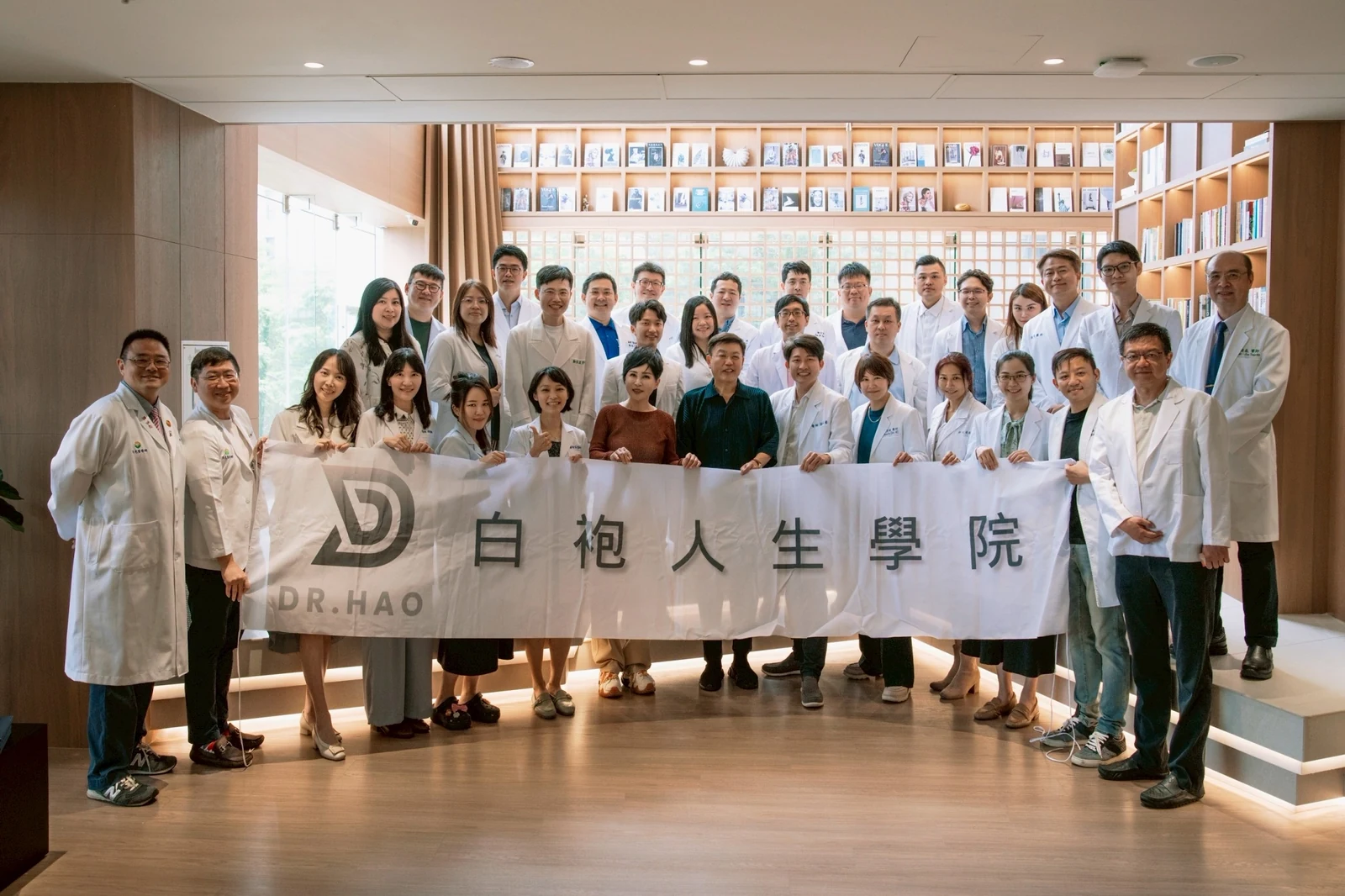 白袍人生學院參訪馬光中醫信義旗艦店的大合照，35 位跨科別醫師在書牆前拉起白袍人生學院布條