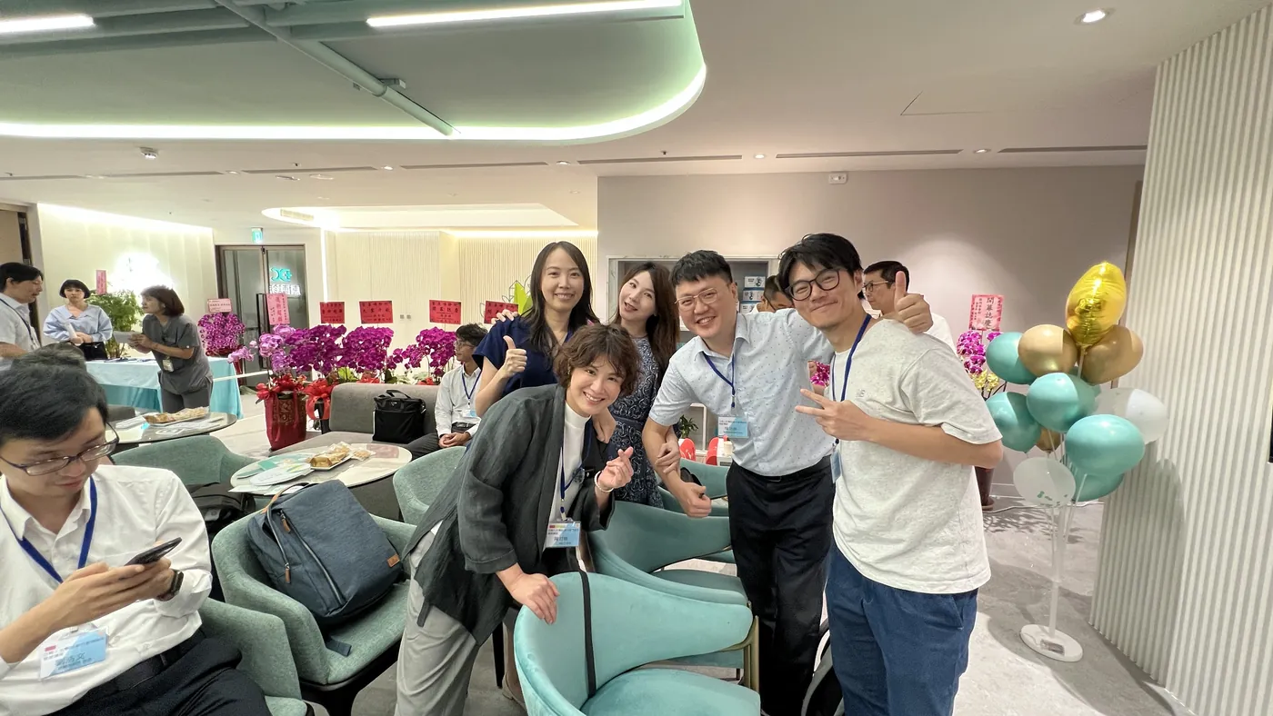 張益豪醫師與多位與會醫師在大廳座位區自拍，後方有氣球與花籃