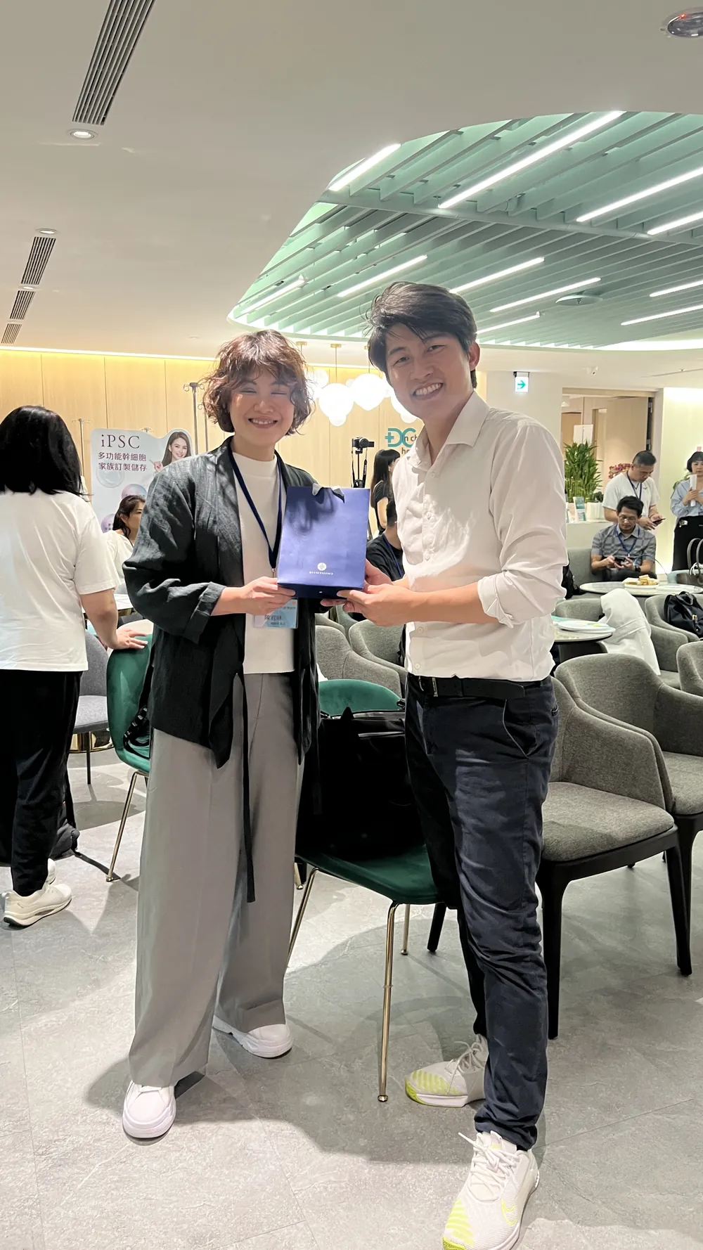 張益豪醫師與陳君琳醫師在座位區合影，陳醫師手上拿著一份深藍色的禮物