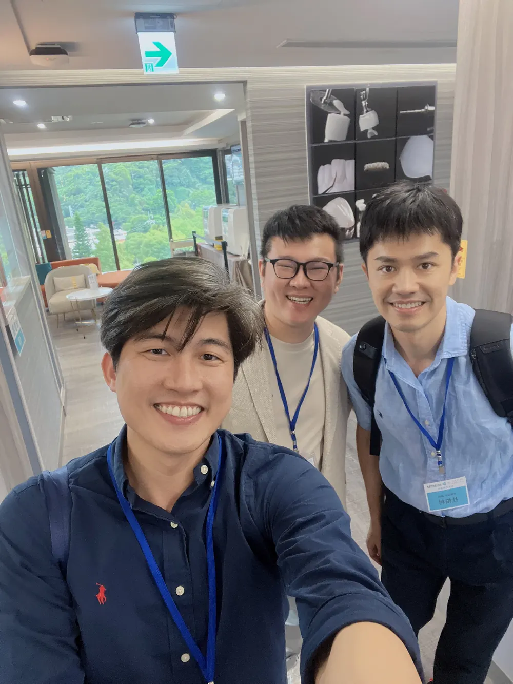 張益豪醫師與兩位先到的醫師自拍，背景是明亮的室內空間與窗外綠意