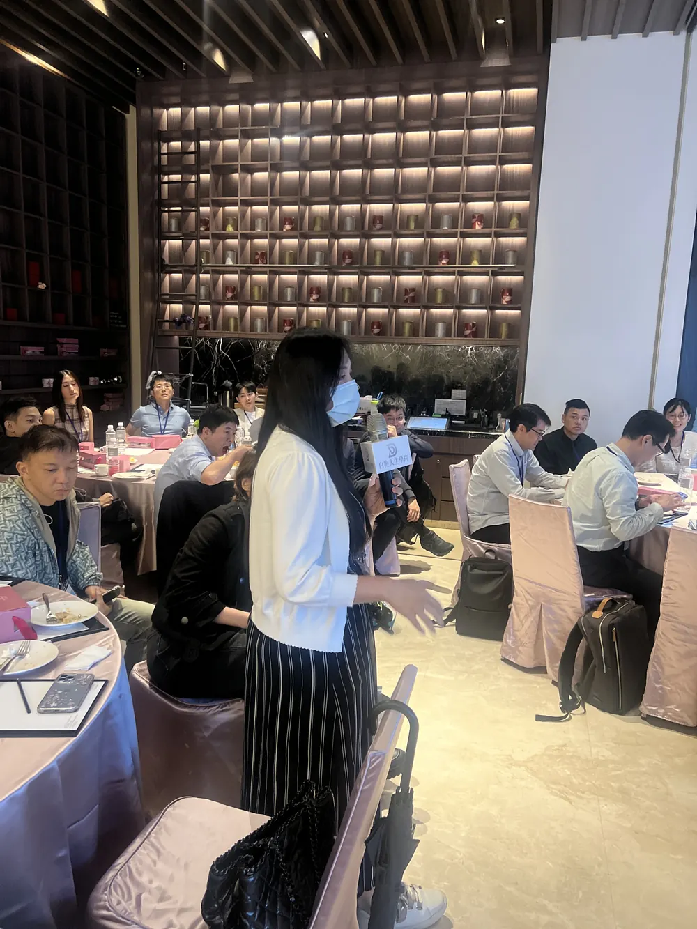 一位戴口罩的與會者手持麥克風發言