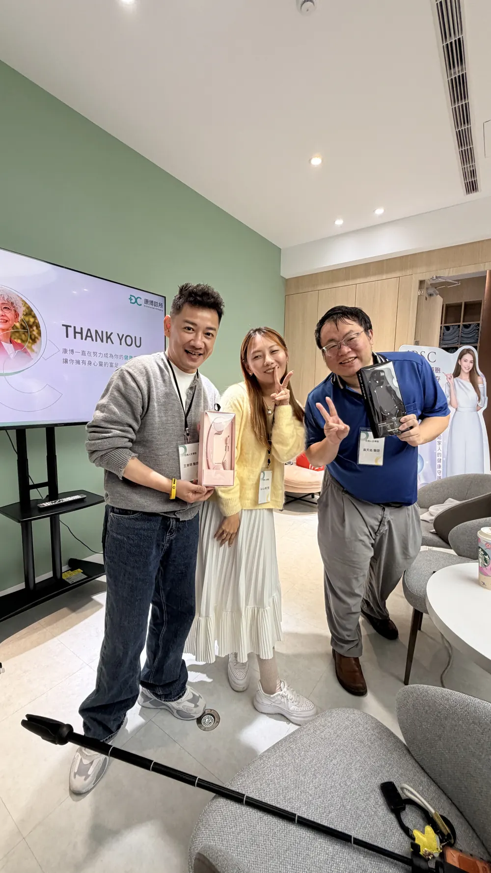三位與會者在螢幕前比手勢合影