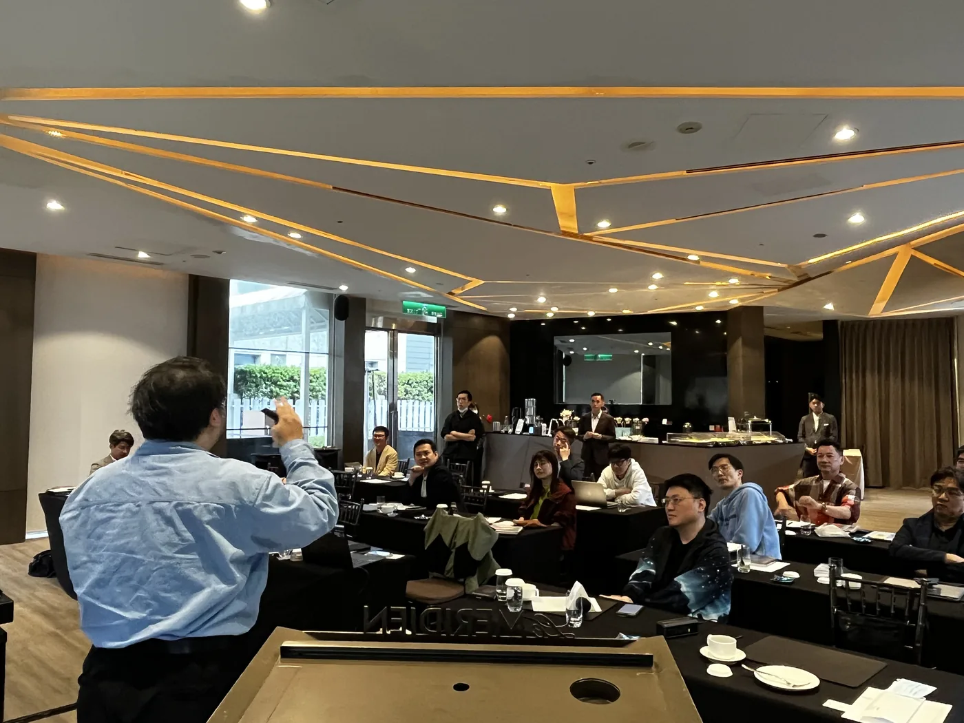 從講者後方拍向台下，與會者專注聽講