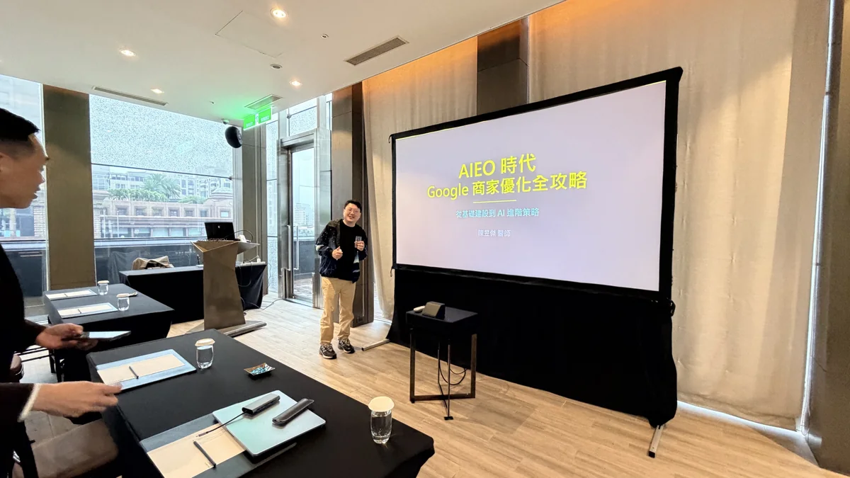 陳昱傑醫師站在「AIEO 時代 Google 商家優化全攻略」講題首頁投影片旁分享