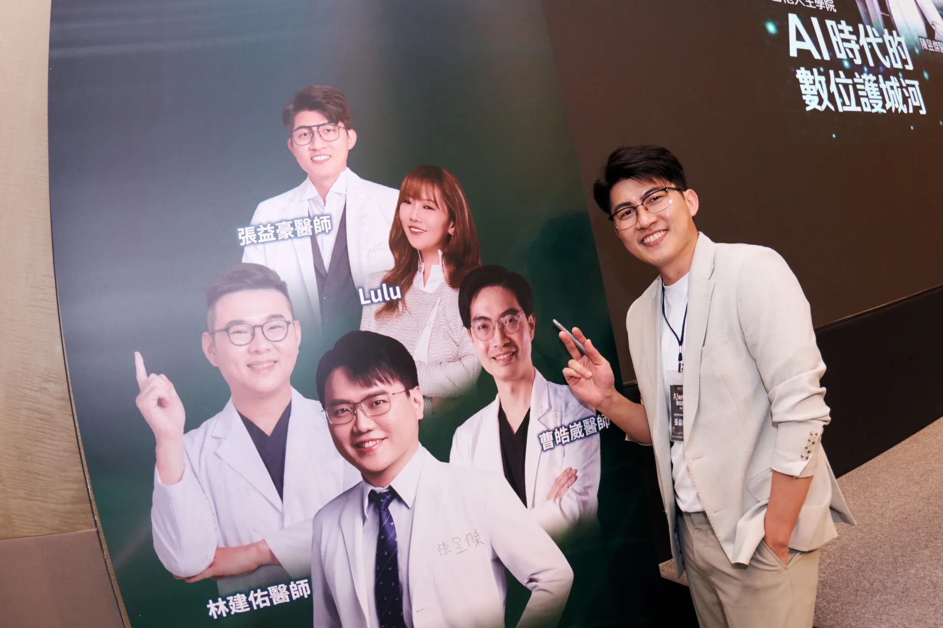 張益豪醫師站在醫師內容創作者與合作夥伴主視覺牆前